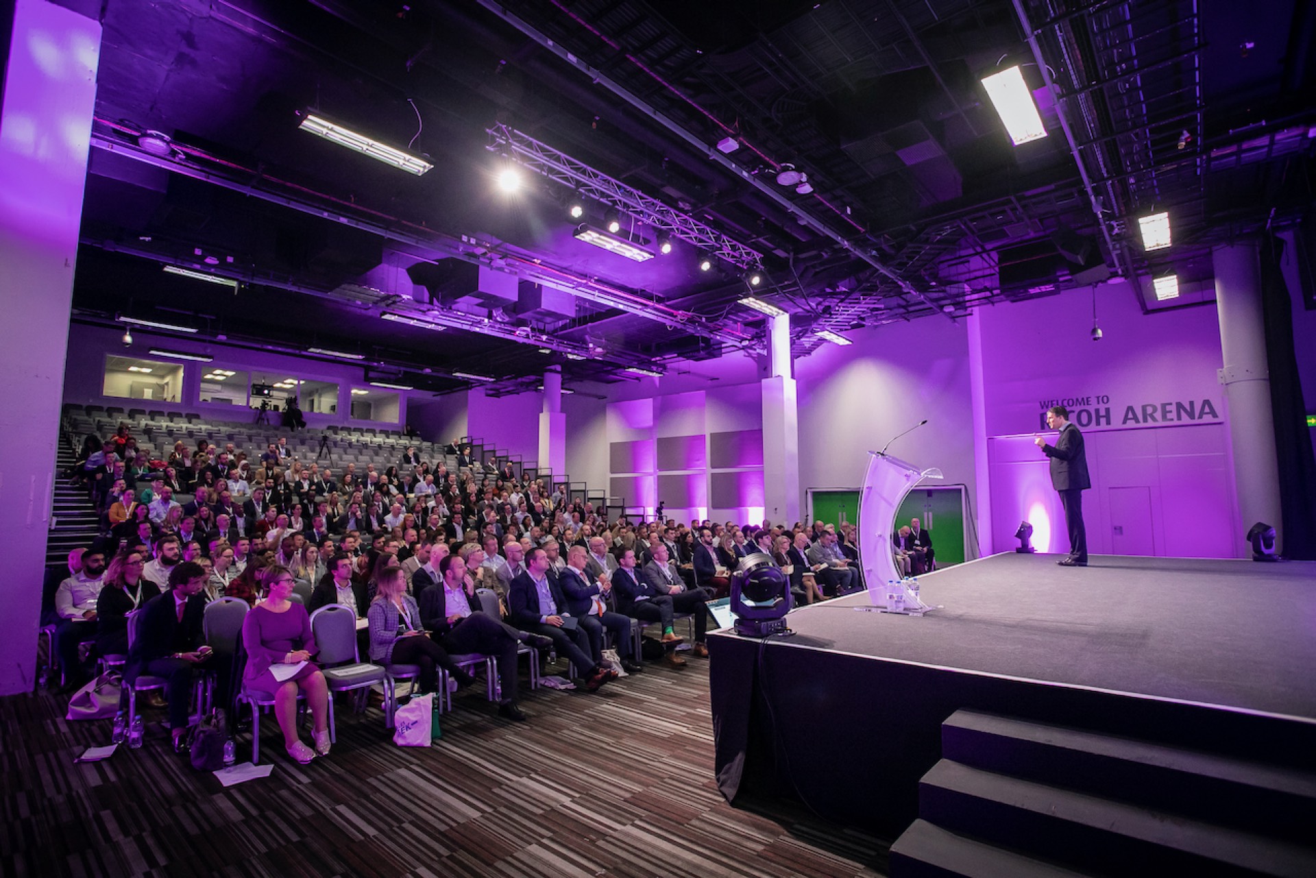 Steve McNicholas on stage in front of a packed arena audience